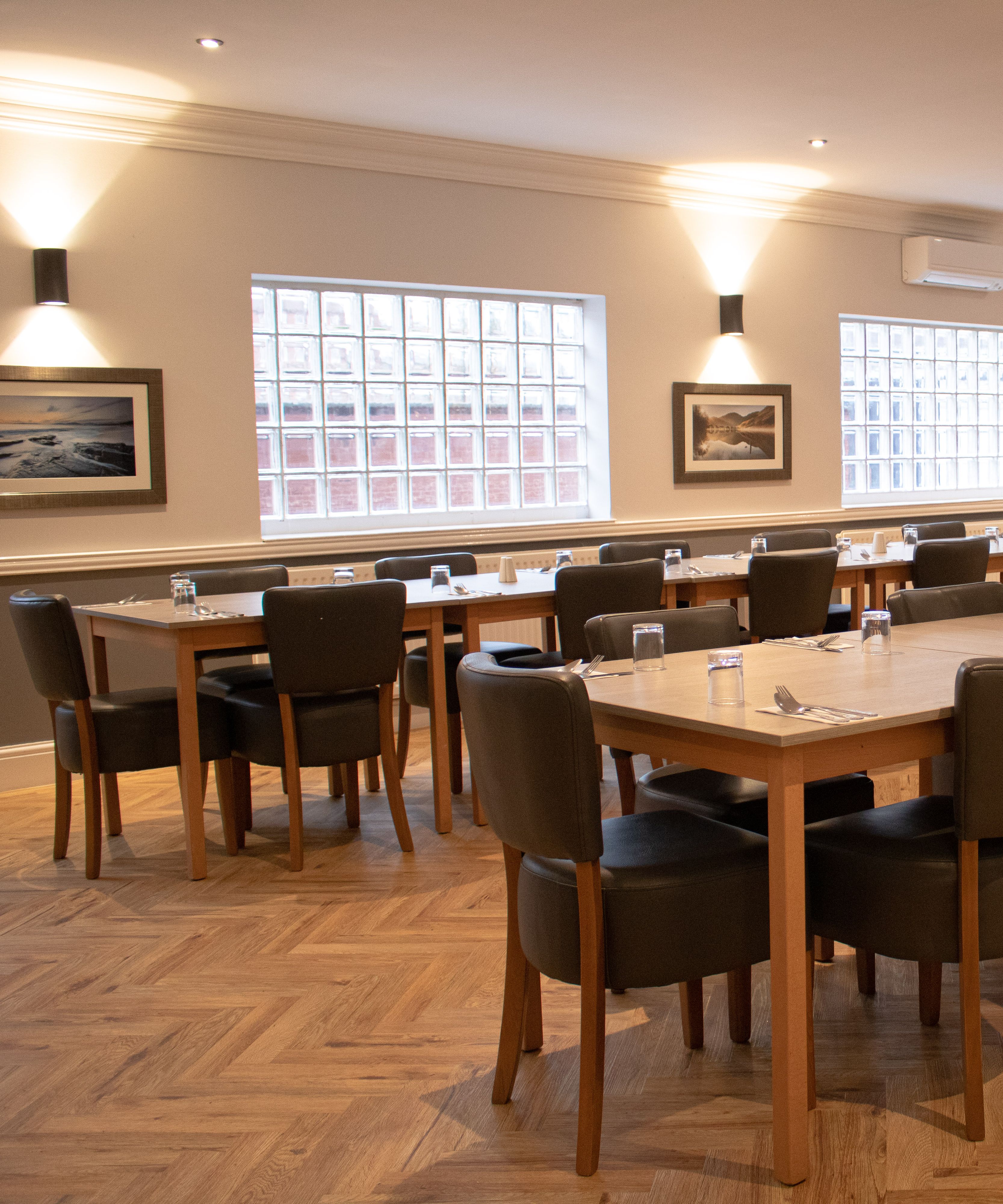 Spacious event room with modern decor, set up with tables and chairs for a meeting or dining event.