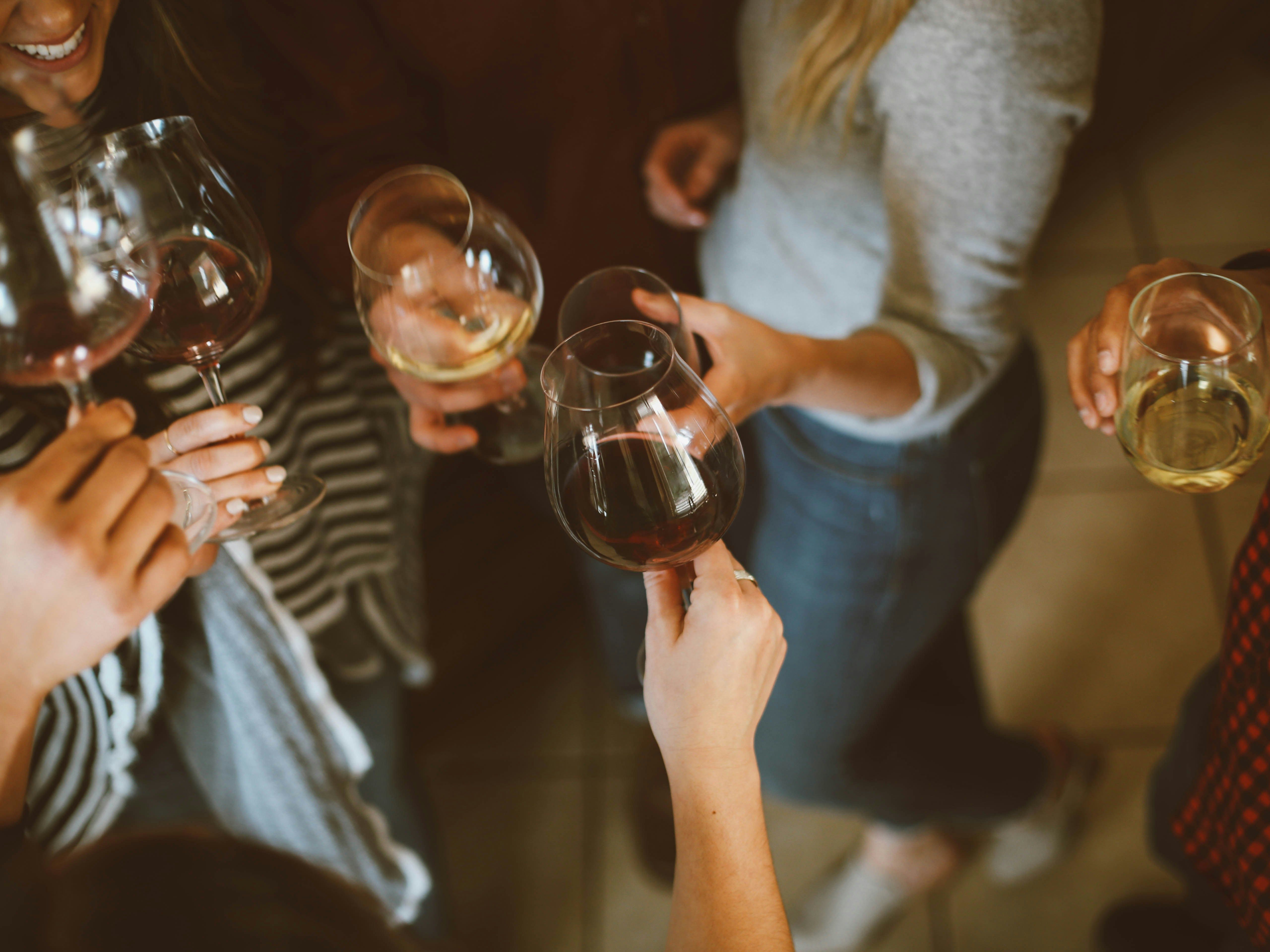 Group of people holding wine glasses and toasting