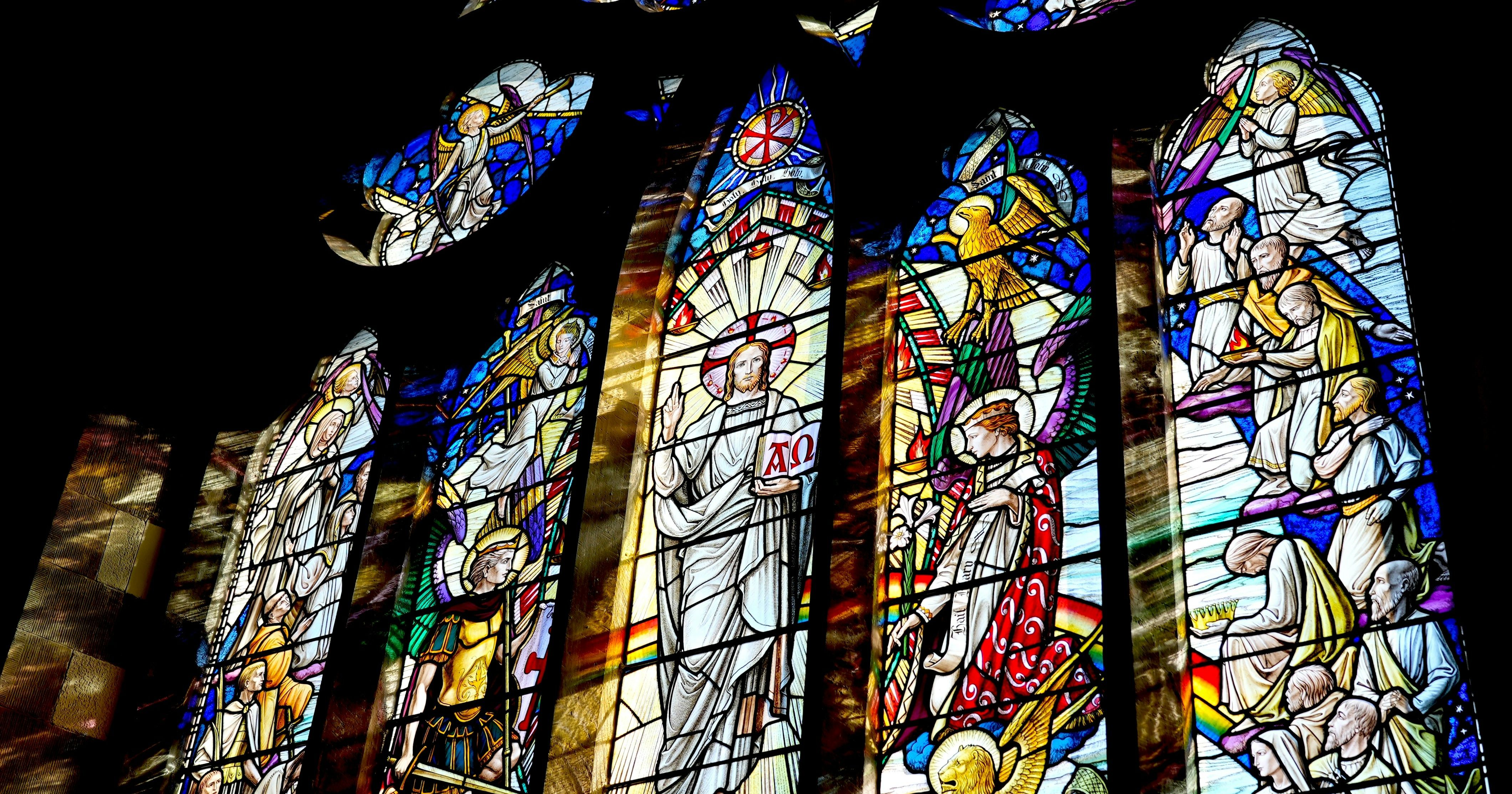 Colorful stained glass window depicting religious figures and scenes in a church