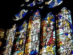 Colorful stained glass window depicting religious figures and scenes in a church