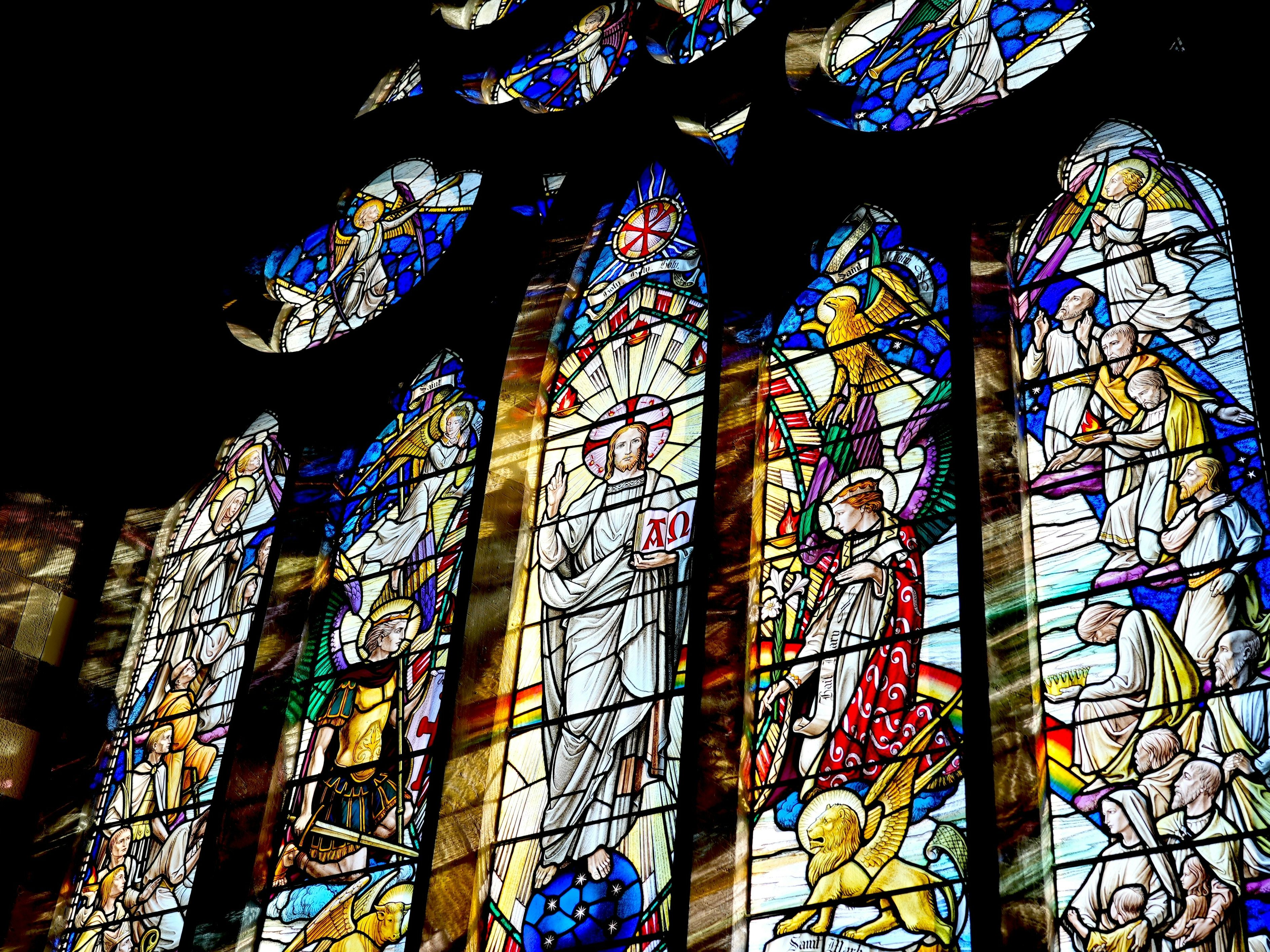 Colorful stained glass window depicting religious figures and scenes in a church