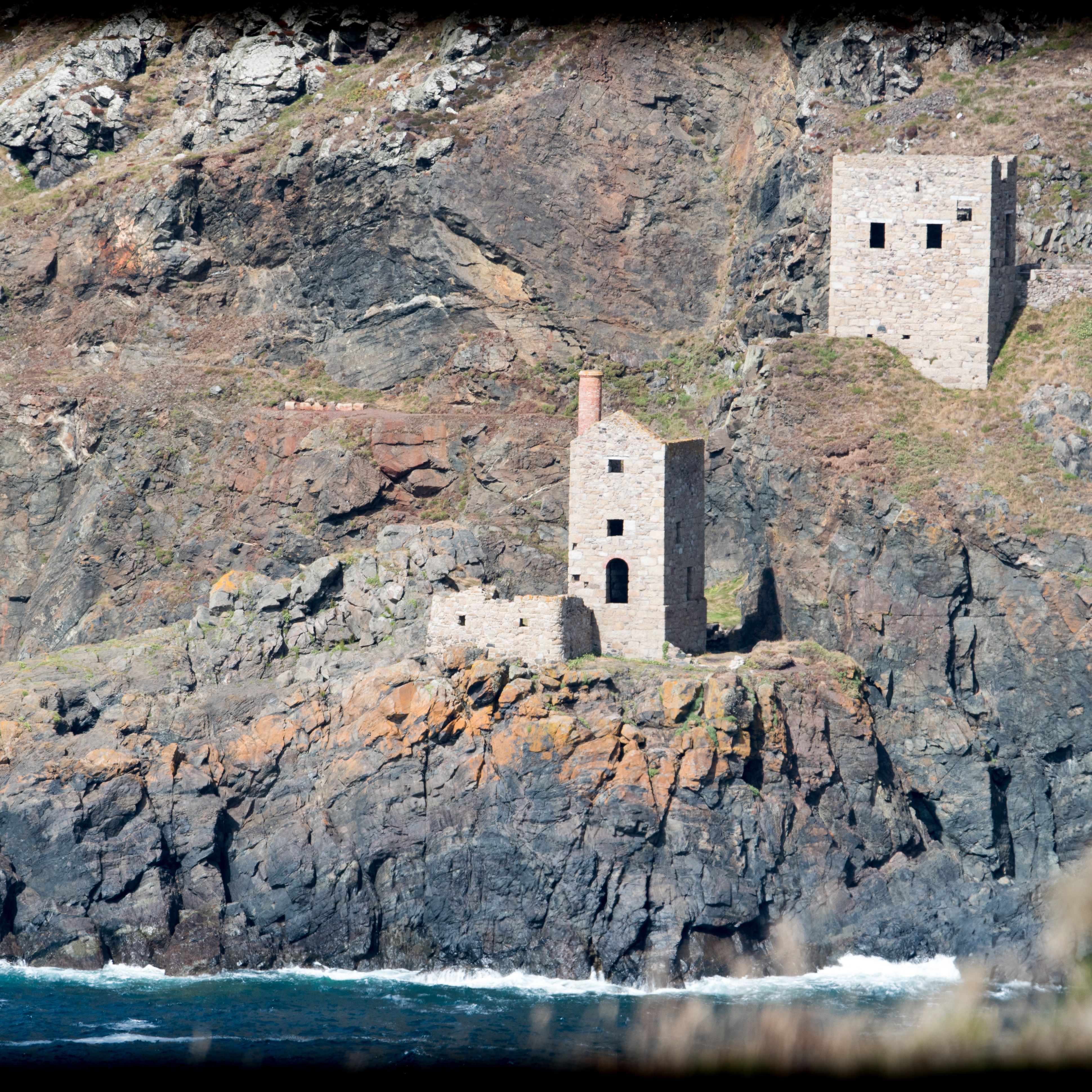 Historic stone buildings on a rugged cliff above the ocean