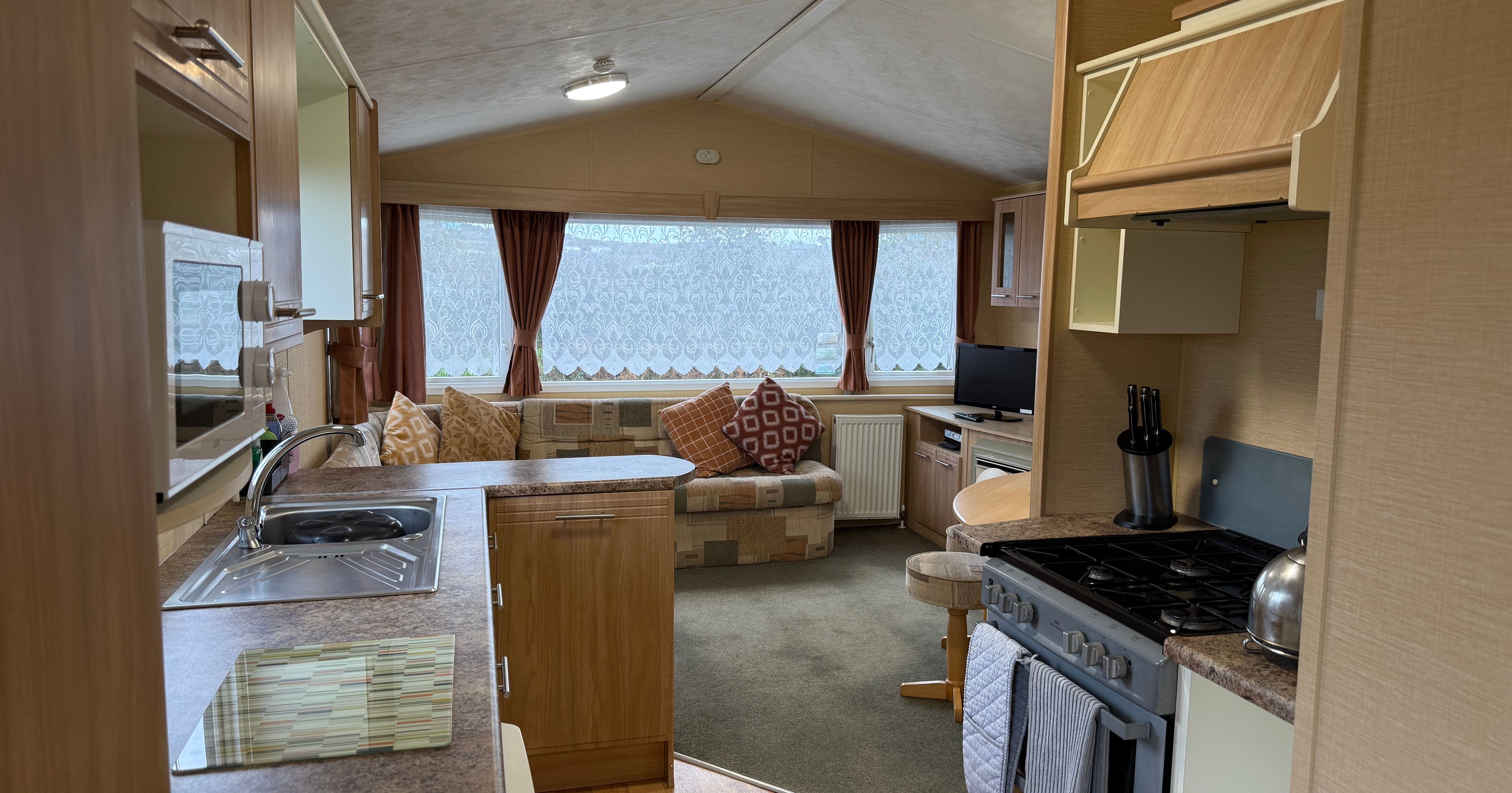 Interior of a cozy caravan with kitchen and living area.