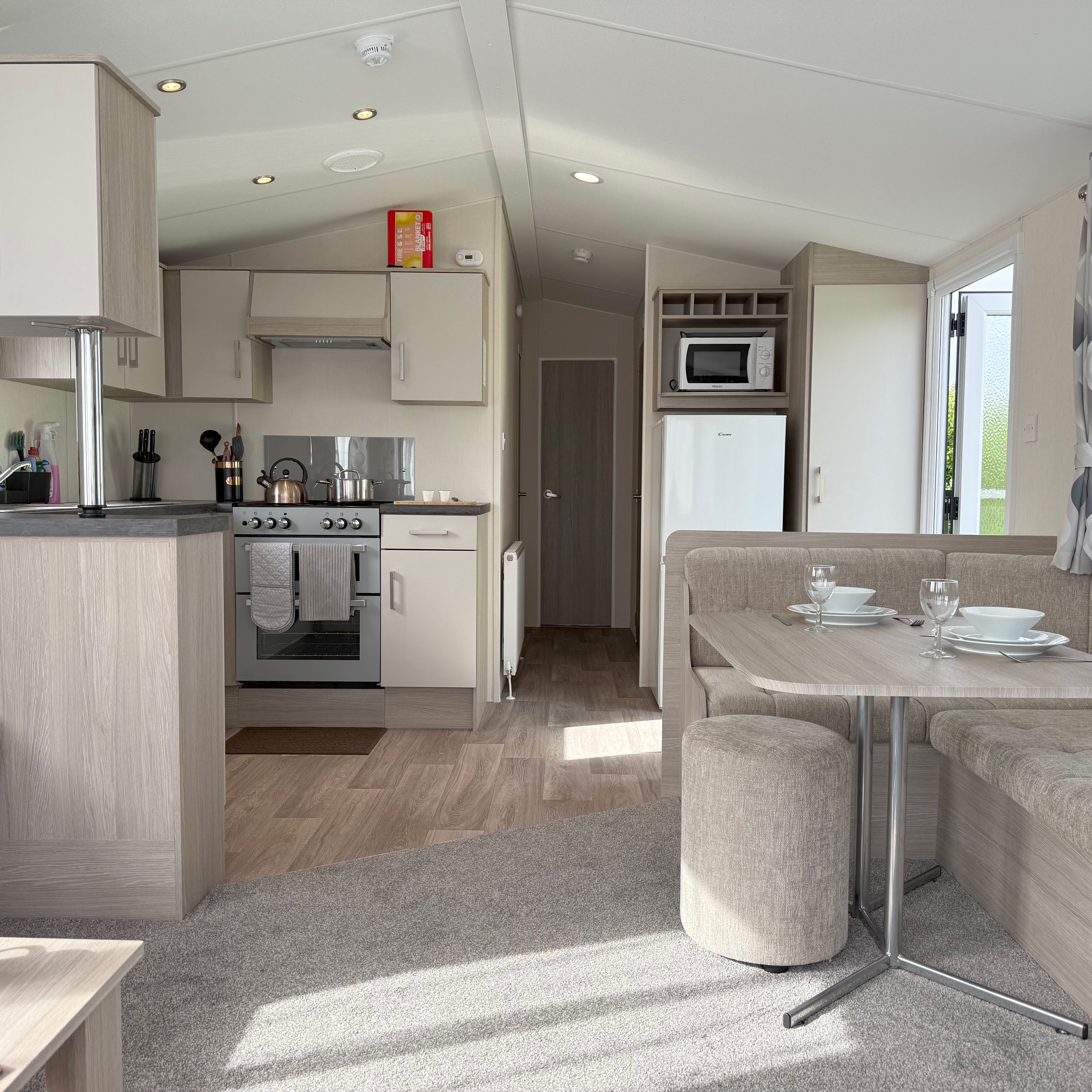 Modern caravan interior with kitchen, dining area, and living space