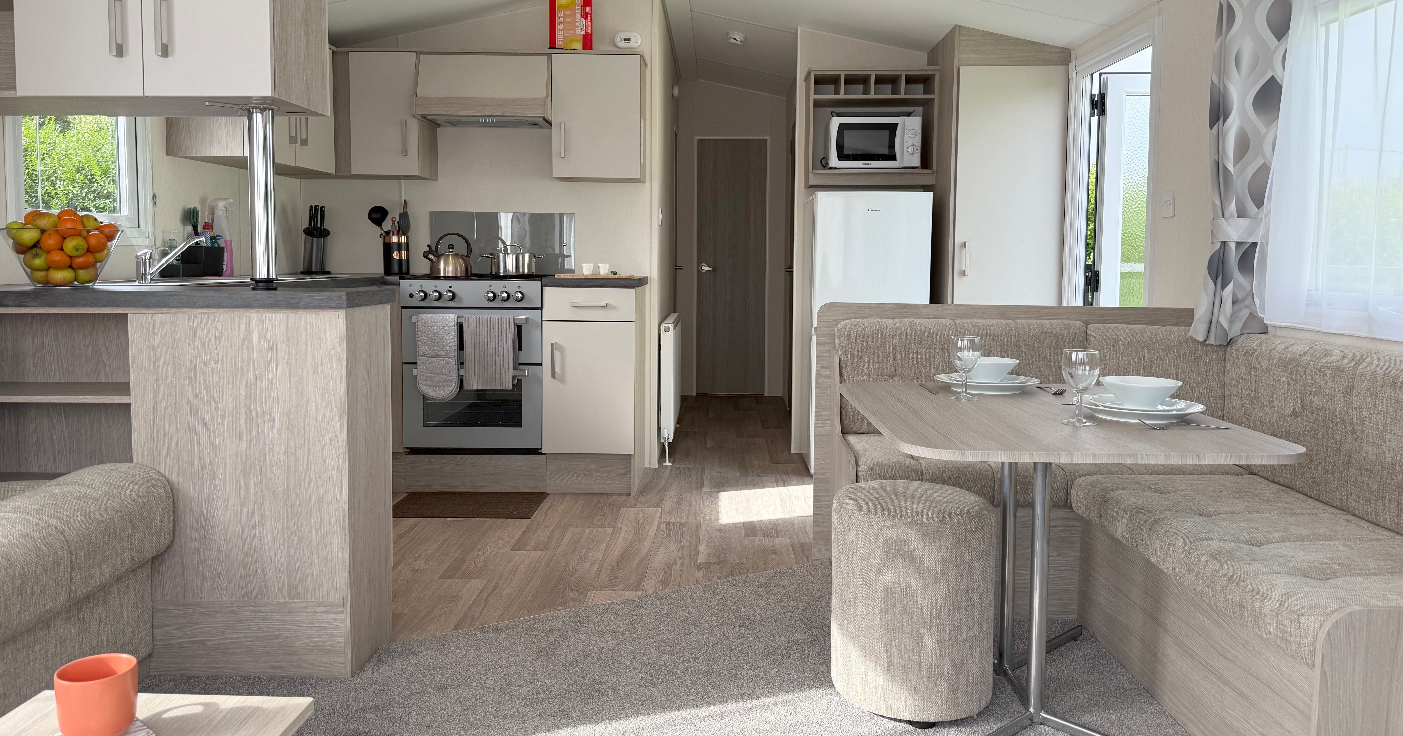 Modern caravan interior with kitchen, dining area, and living space