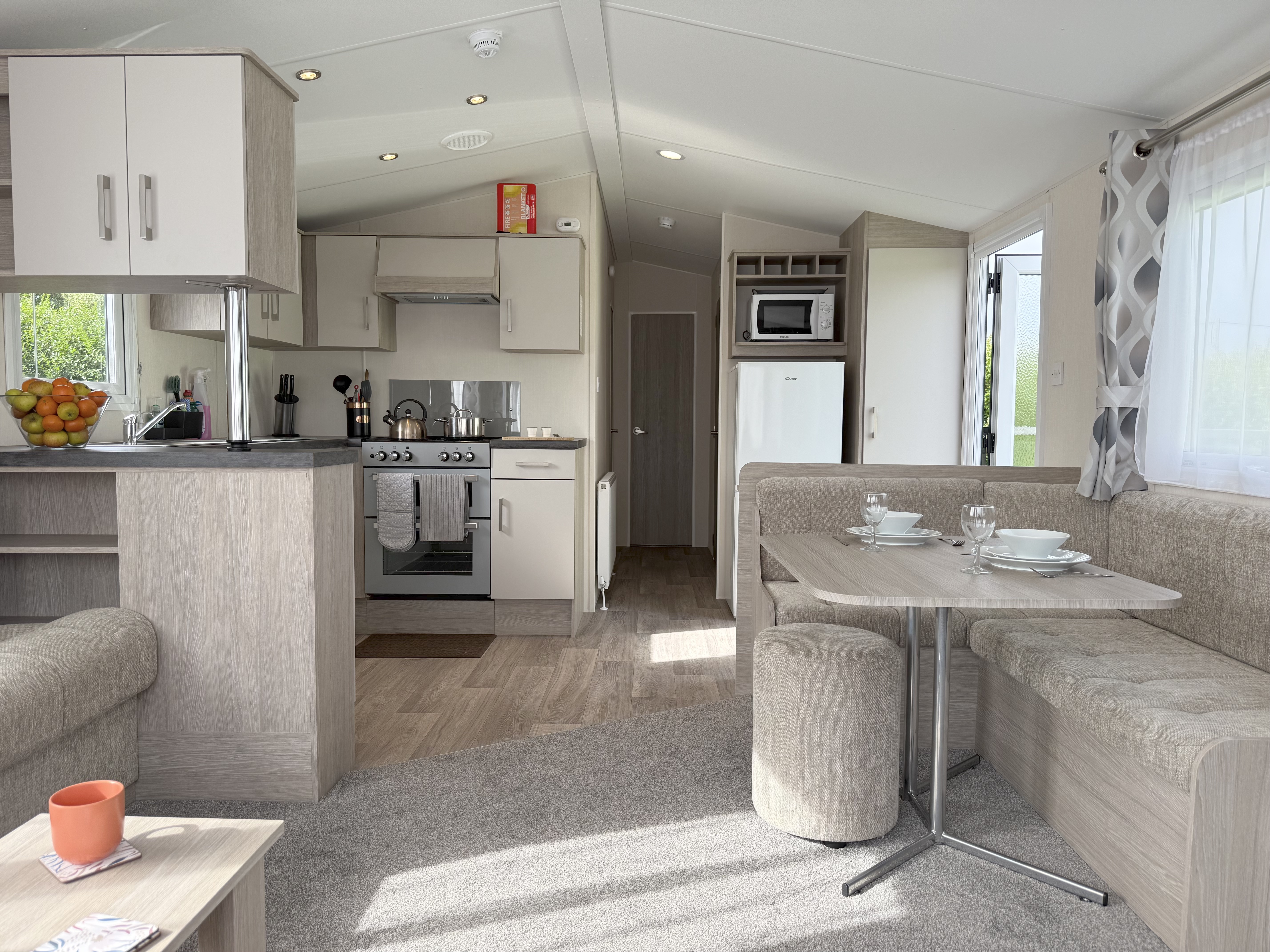 Modern caravan interior with kitchen, dining area, and living space