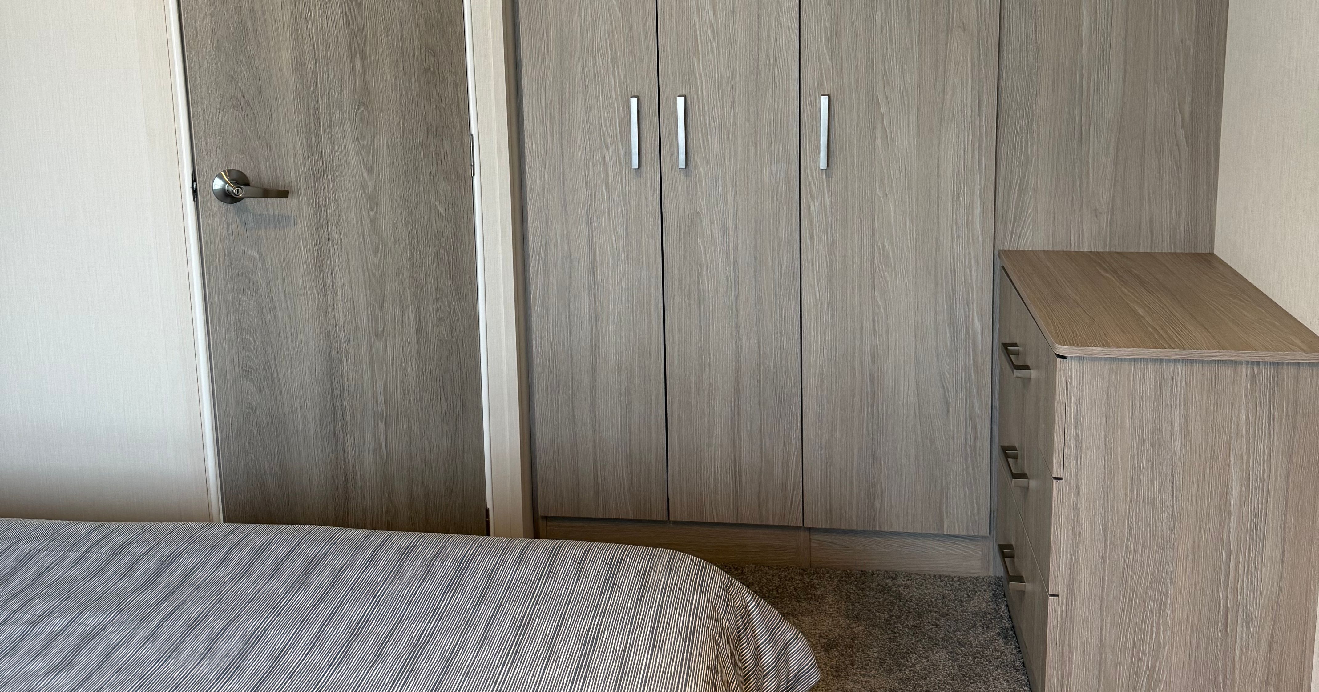 Modern bedroom with gray wardrobe and chest of drawers