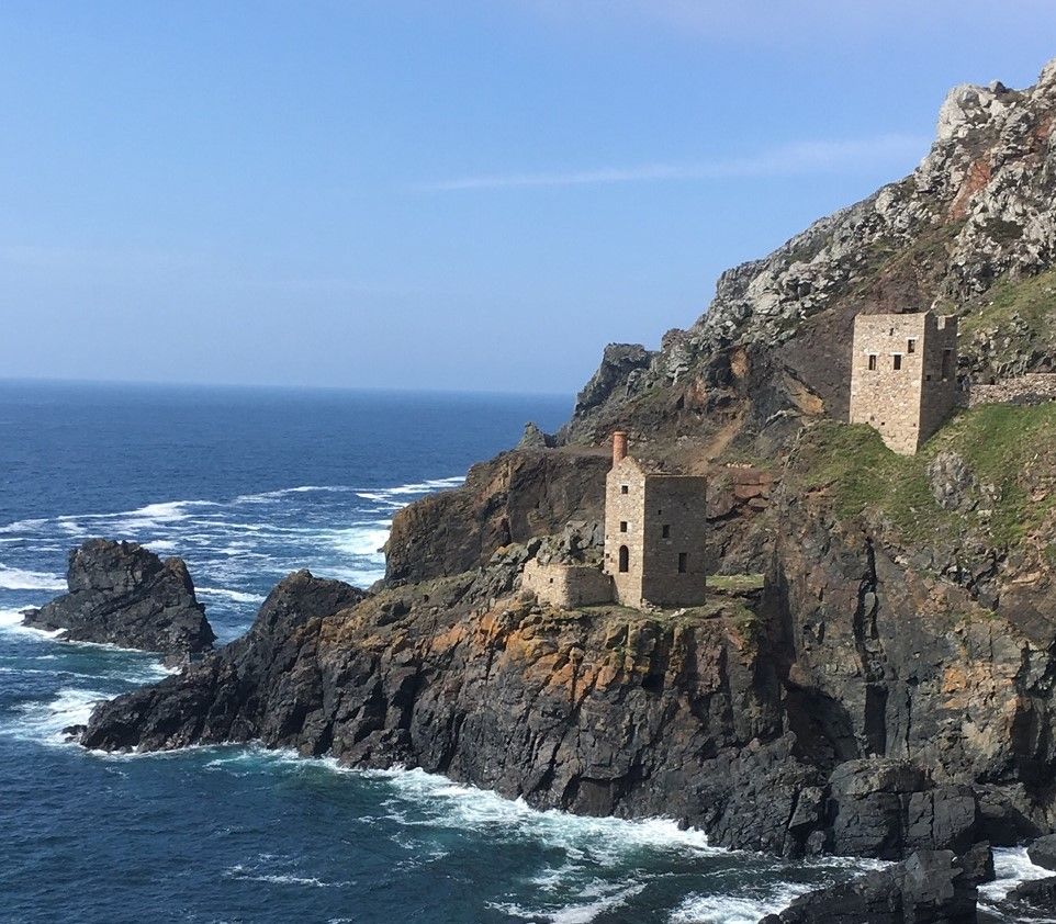 Historic stone buildings on rugged cliffside by the sea
