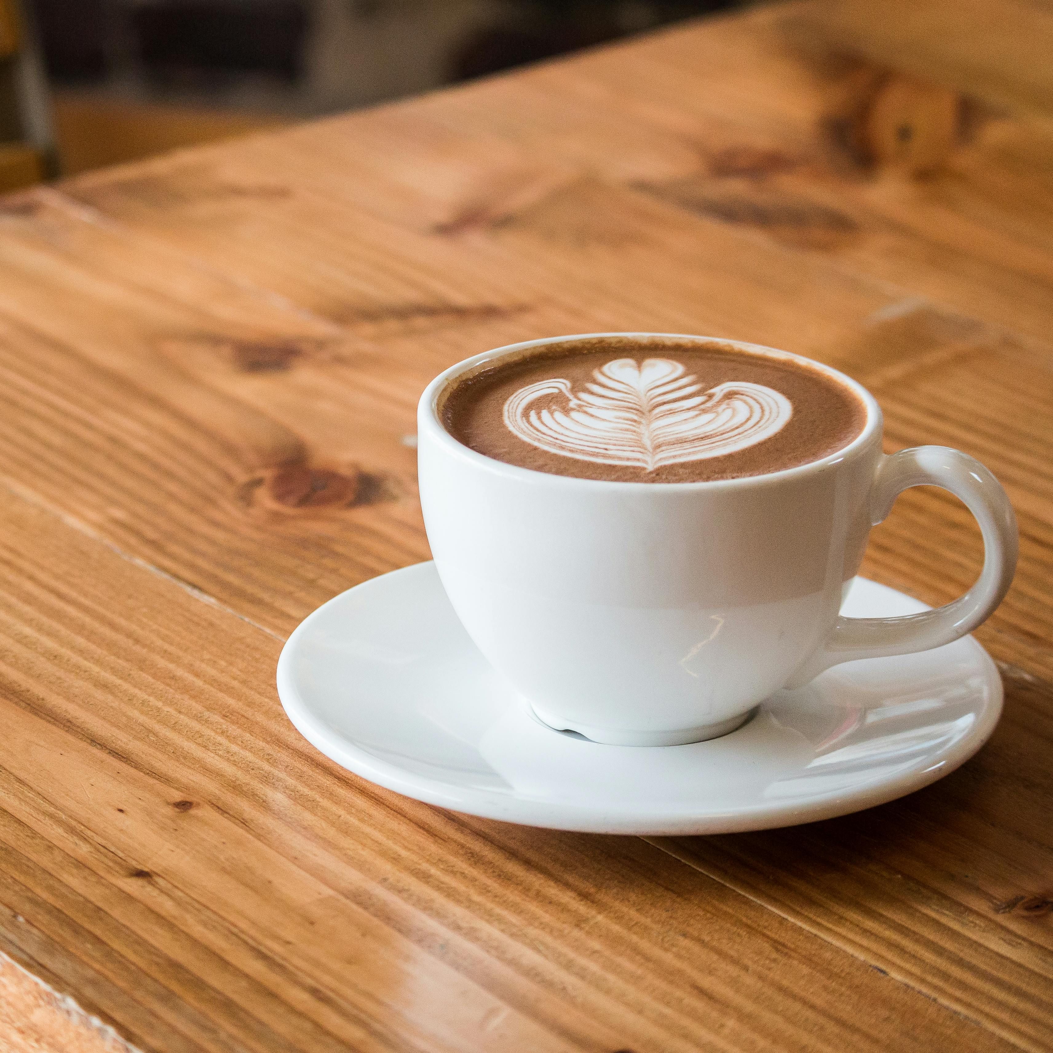 A cup of coffee with latte art on a wooden table