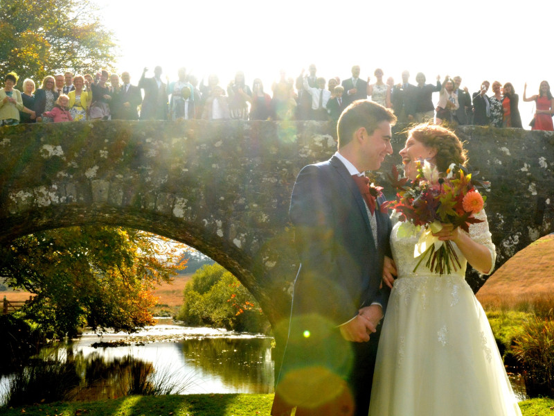 People stood on a bridge celebrating the married couple