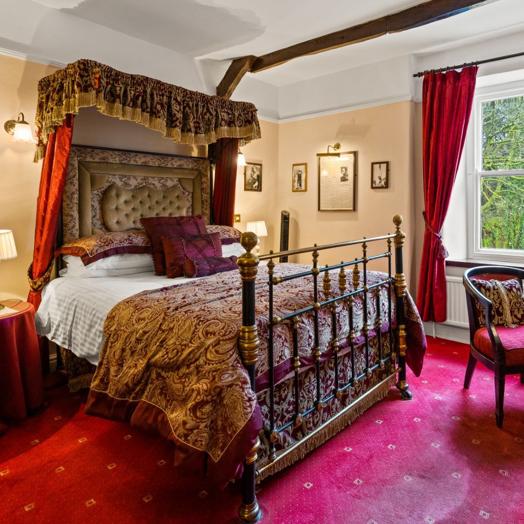Luxurious vintage hotel room with four-poster bed, ornate fabrics, and traditional decor