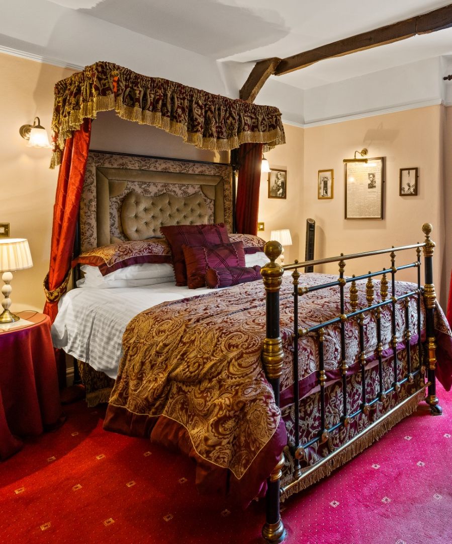 Luxurious vintage hotel room with four-poster bed, ornate fabrics, and traditional decor
