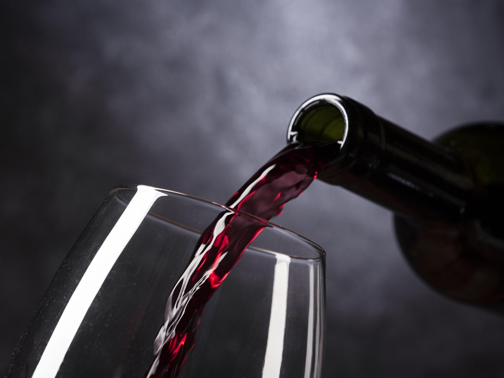 Red wine being poured from a bottle into a glass
