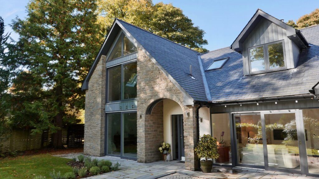 Modern house with large glass windows, stone and slate exterior