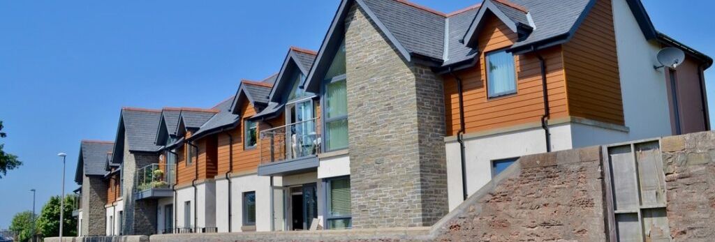 Modern townhouses with brick and wood panel exteriors on a sunny day