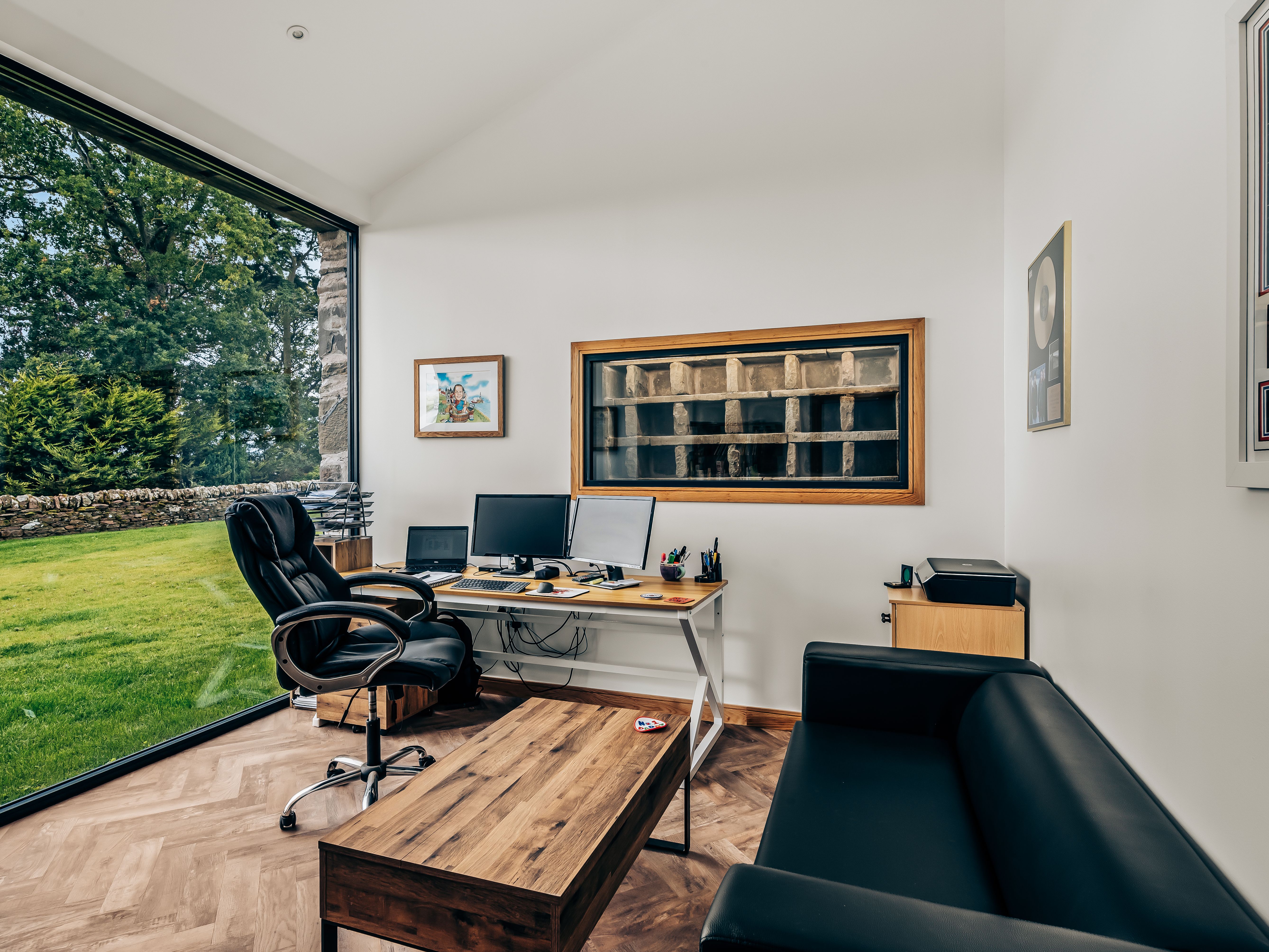 Modern home office with a large window overlooking a green yard
