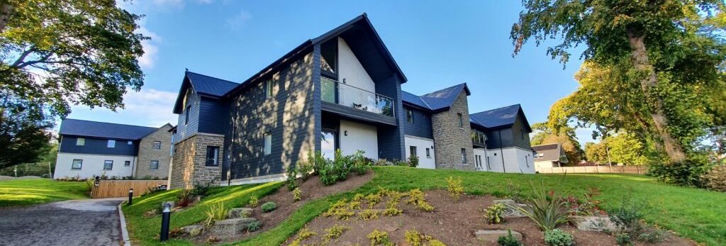Modern residential building with landscaped garden on a sunny day