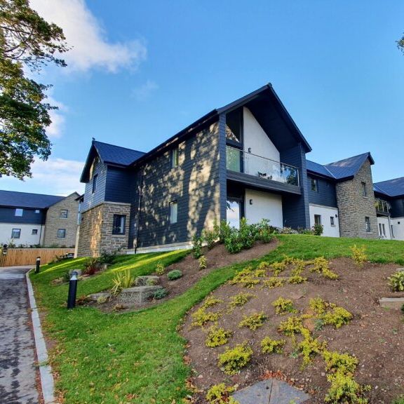 Modern residential building with landscaped garden on a sunny day