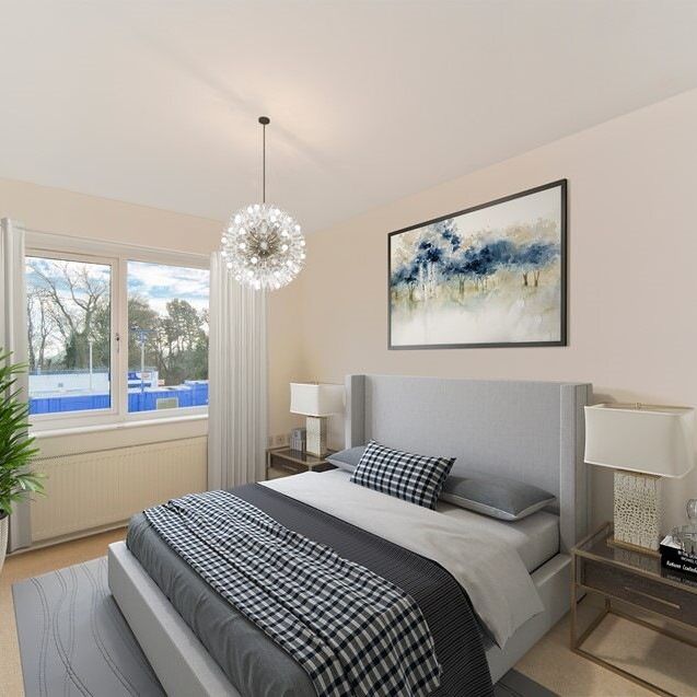 Modern bedroom with grey and white decor, large bed, abstract wall art, and a potted plant by the window.