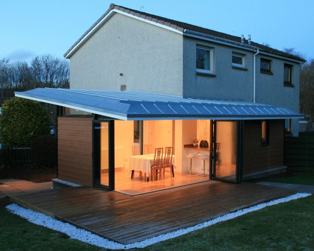 Modern house extension with large glass doors and wooden deck