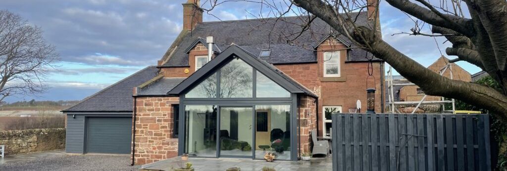 Traditional stone house with modern glass extension and a large garden
