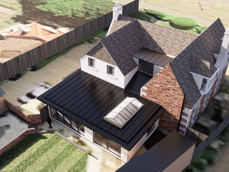 Aerial view of a modern house extension with glass roof, attached to a traditional brick house