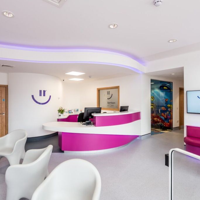 Modern dental clinic reception area with purple and white accents, waiting chairs, and a welcoming environment.