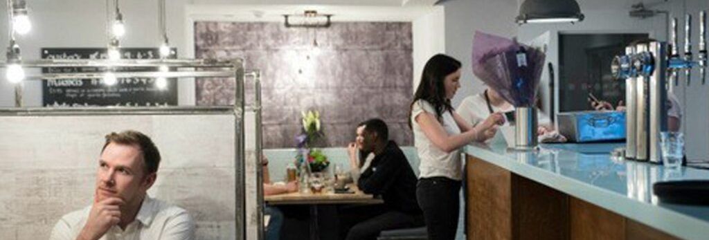People sitting and standing inside a modern cafe with industrial decor