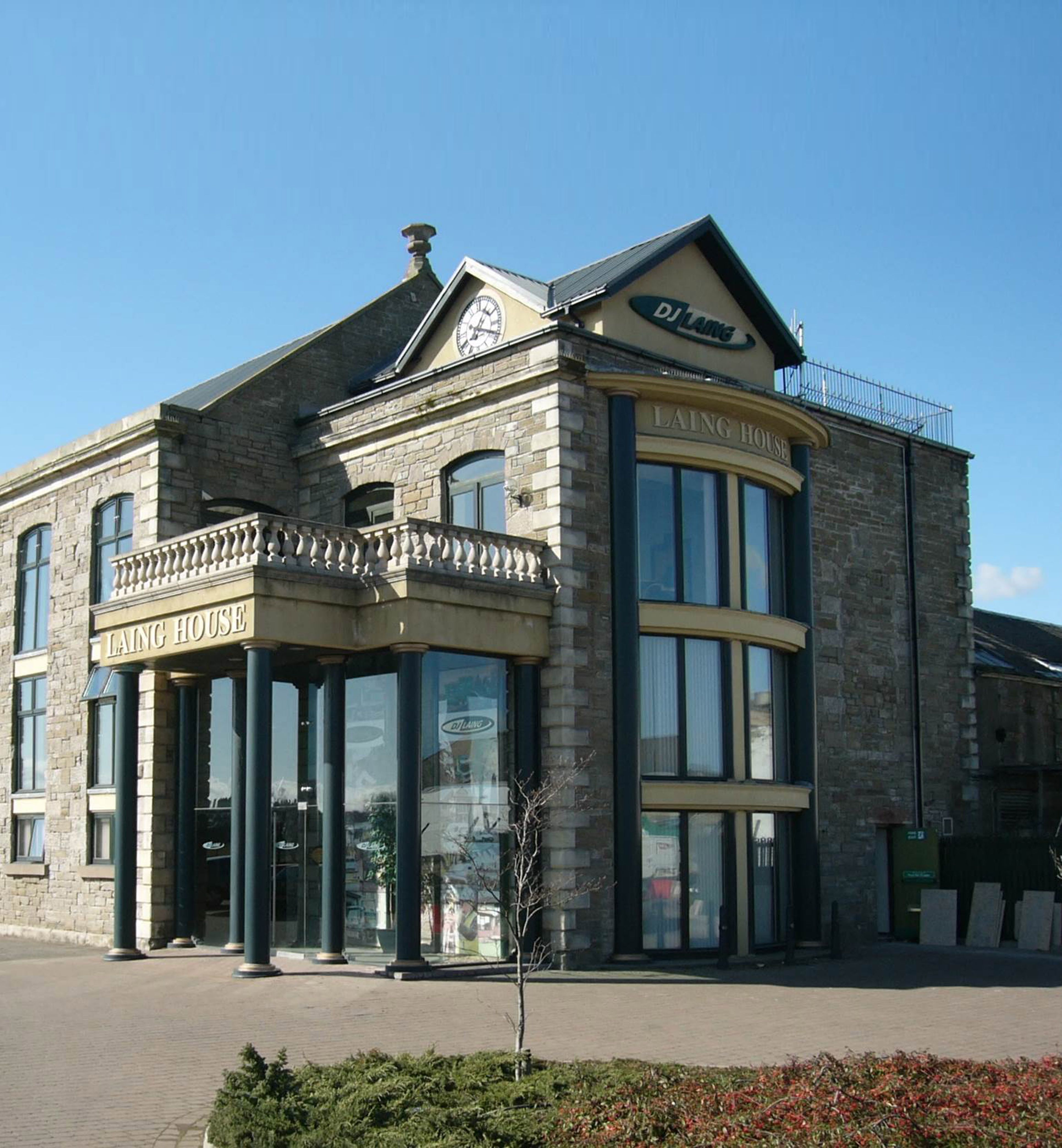 Stone commercial building with large glass windows and a sign reading 'Laing House'