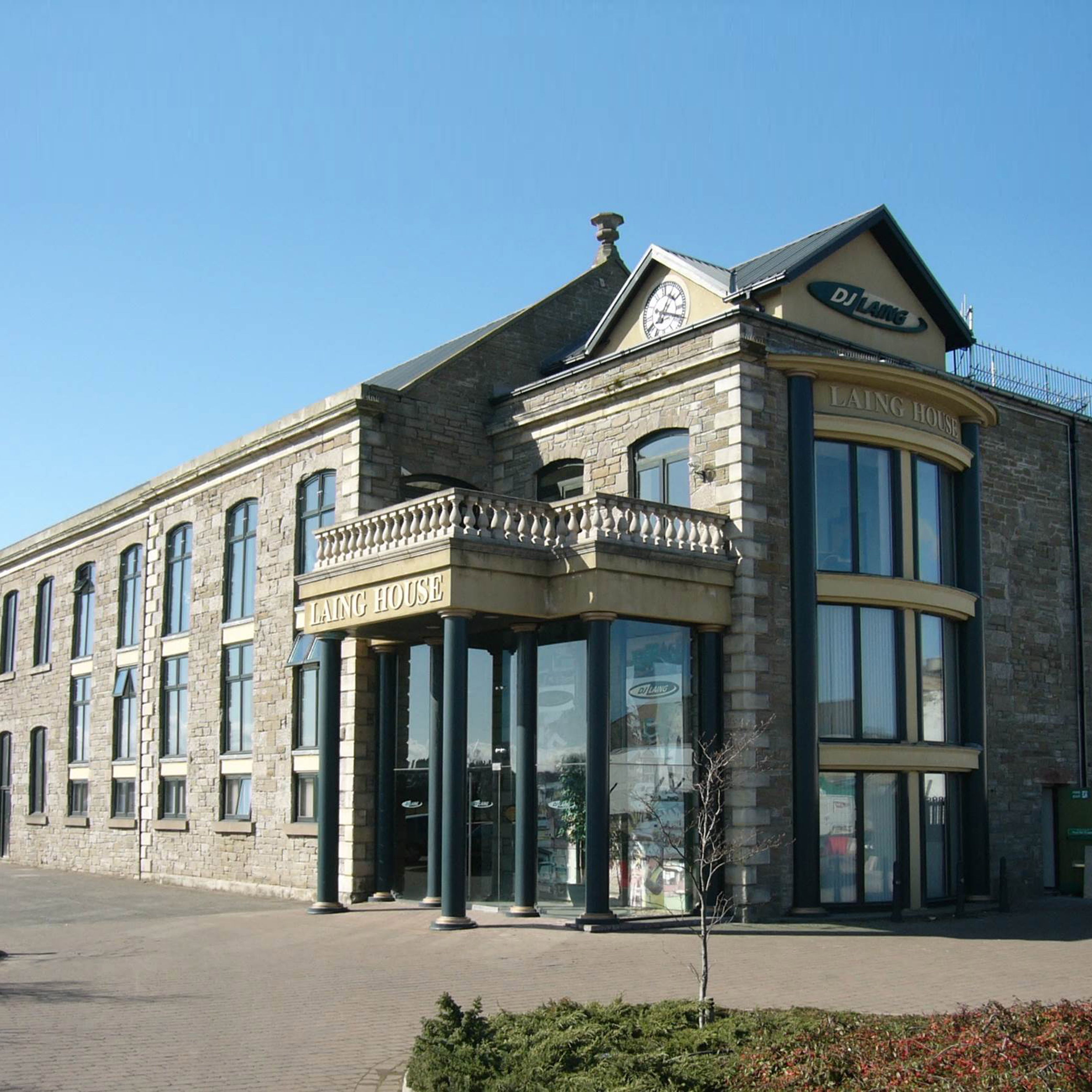 Stone commercial building with large glass windows and a sign reading 'Laing House'