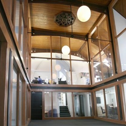 Modern office space with large glass windows and wooden ceiling