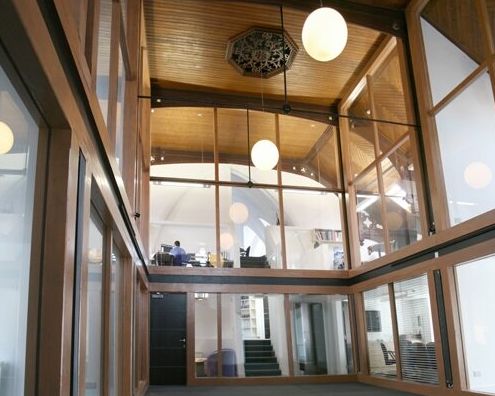Modern office space with large glass windows and wooden ceiling