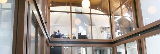 Modern office space with large glass windows and wooden ceiling