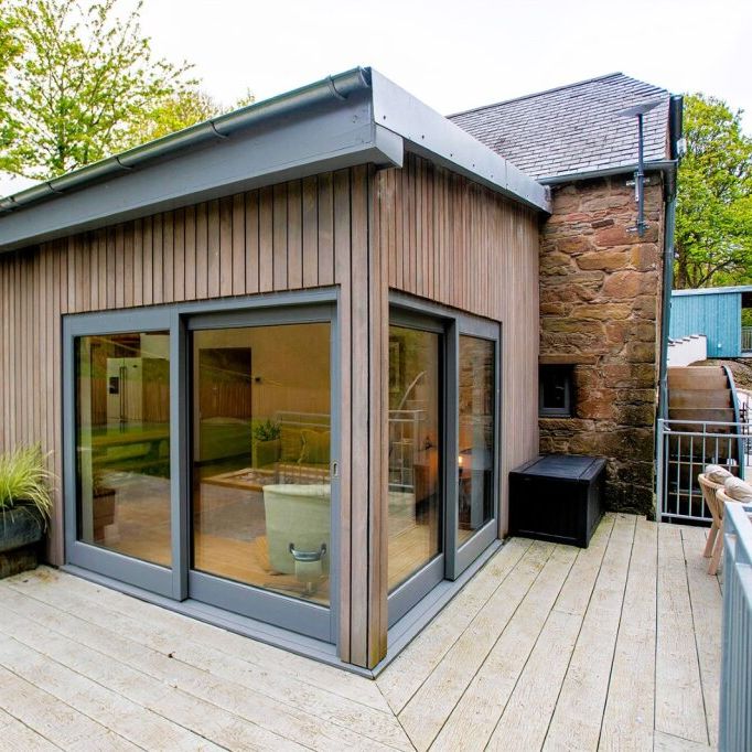 Modern wooden house with large windows and spacious patio area