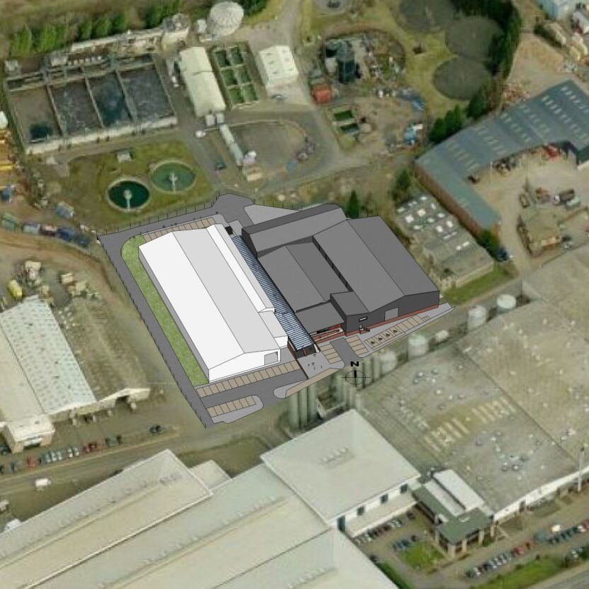 Aerial view of an industrial area with a digital overlay of a proposed building expansion.