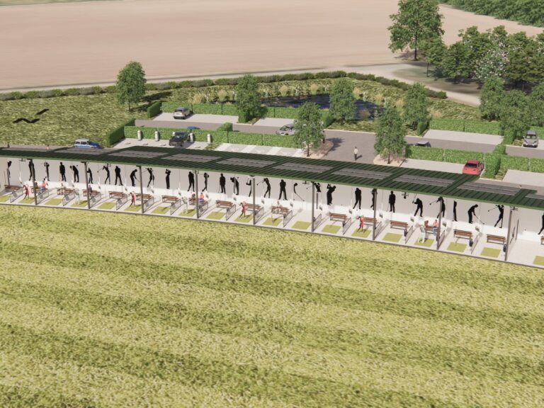 Aerial view of a modern outdoor golf driving range with individual practice bays and nearby parking.