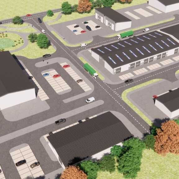 Aerial view of an industrial park with multiple buildings, parking lots, roads, and surrounding greenery.