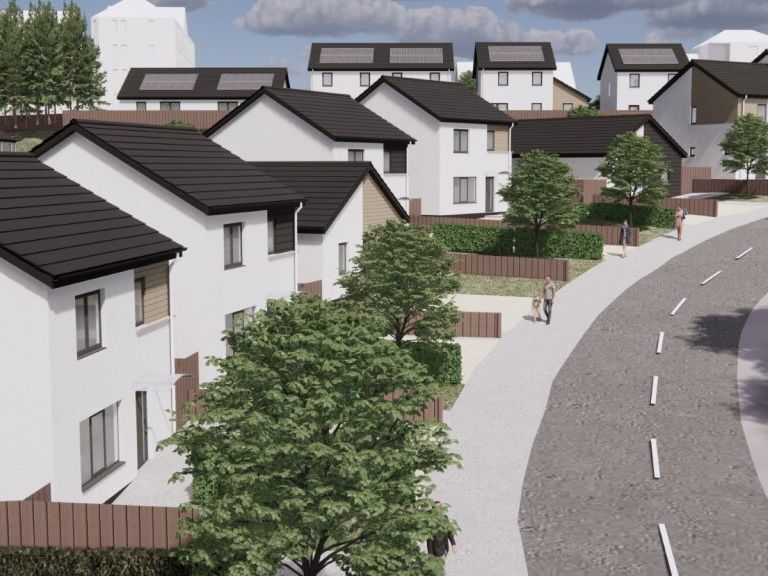 A suburban neighborhood with modern white houses, trees, and a curved road.