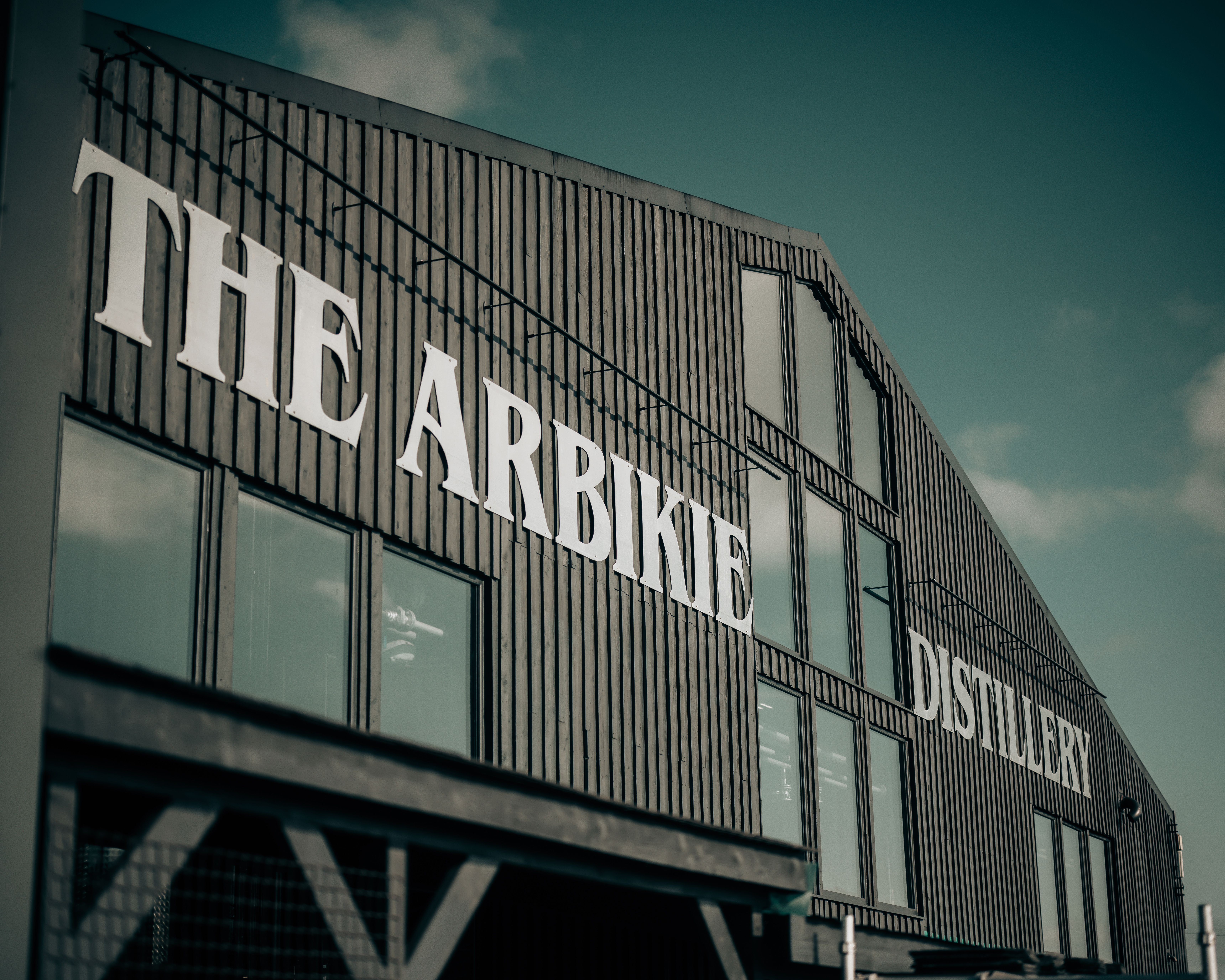 Exterior of The Arbikie Distillery building with large white signage