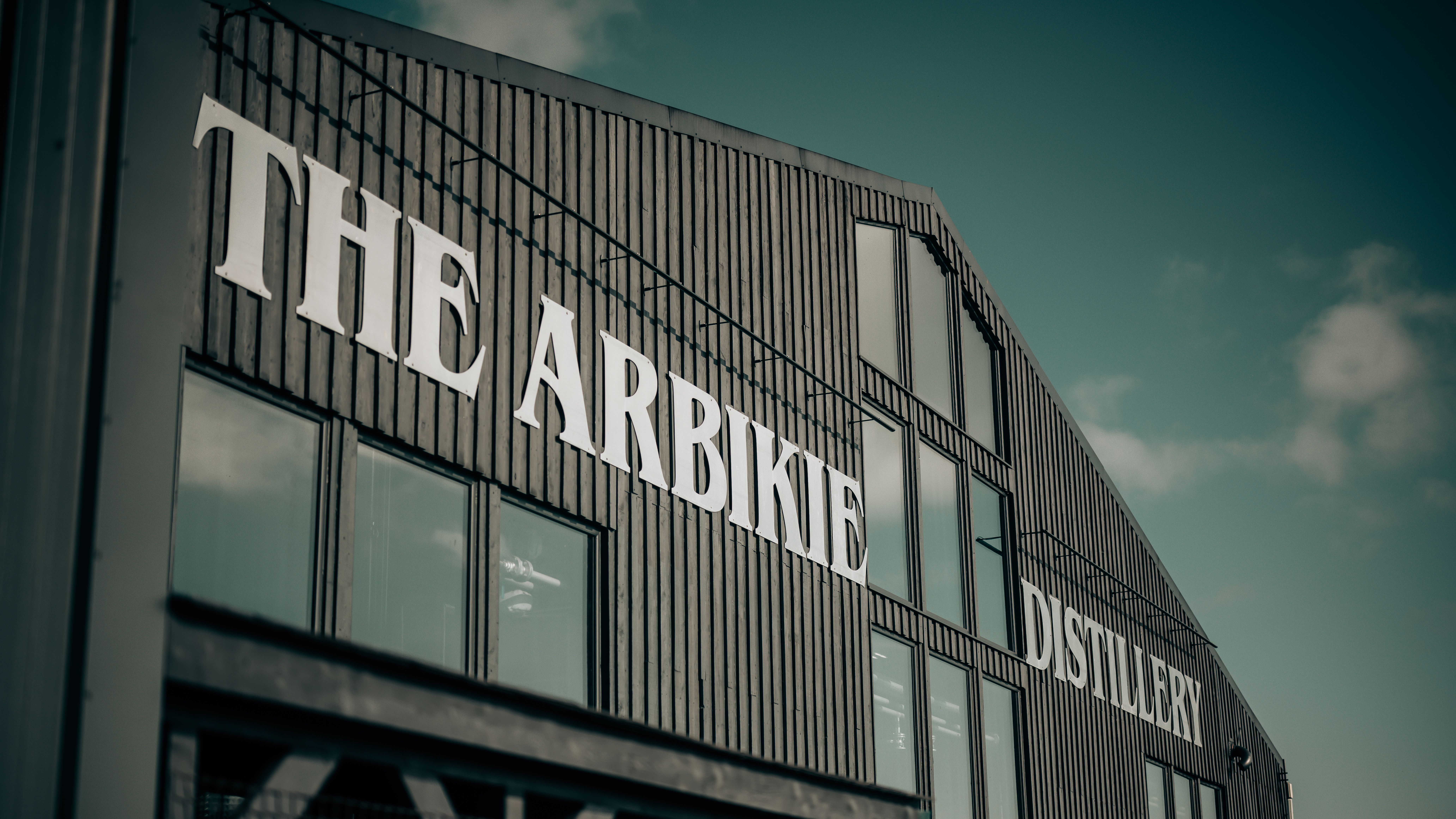 Exterior of The Arbikie Distillery building with large white signage