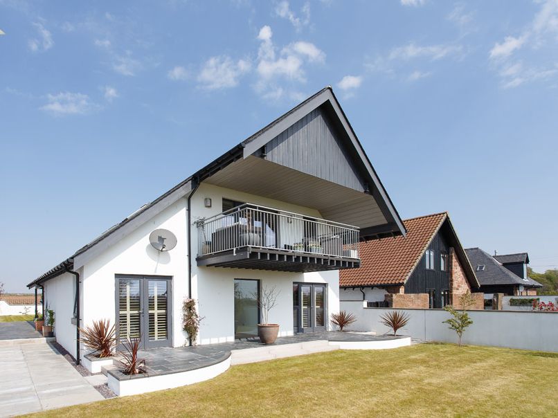 Modern house with a balcony and sloped roof on a sunny day
