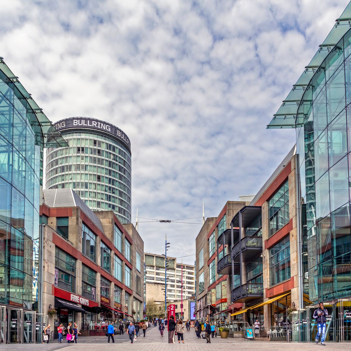 View of Birmingham's Bullring shopping area with modern glass buildings and a tower.