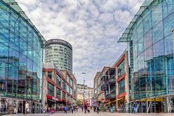 View of Birmingham's Bullring shopping area with modern glass buildings and a tower.