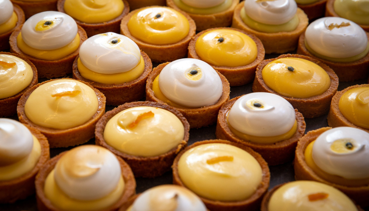 A selection of custard tarts with meringue, featuring glossy and smooth textures.
