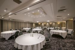 Conference room set up with round tables and chairs, ready for a meeting or event.