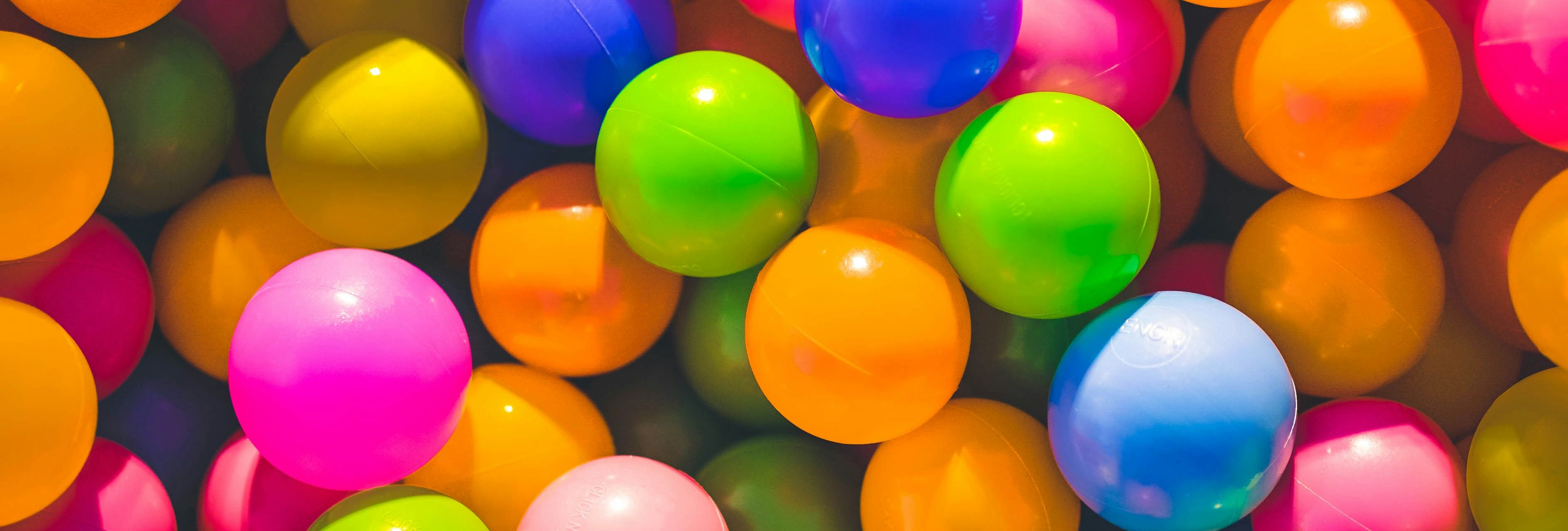 Close-up of brightly coloured plastic balls in a ball pit