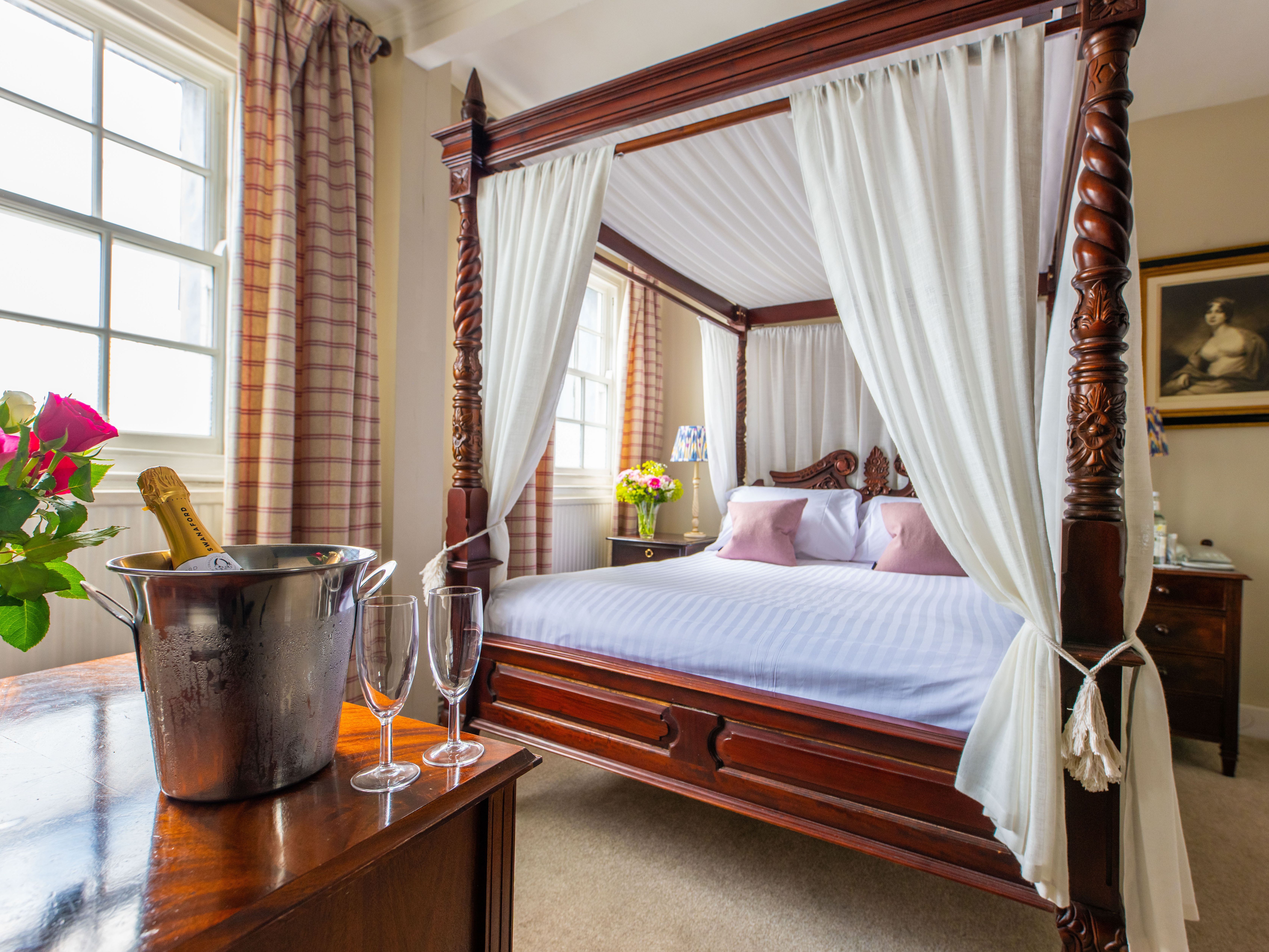 Four poster bed with bucket of champagne and glasses on table