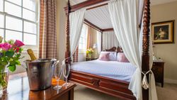 Four poster bed with bucket of champagne and glasses on table