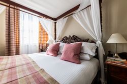 Four poster bed with pink cushions