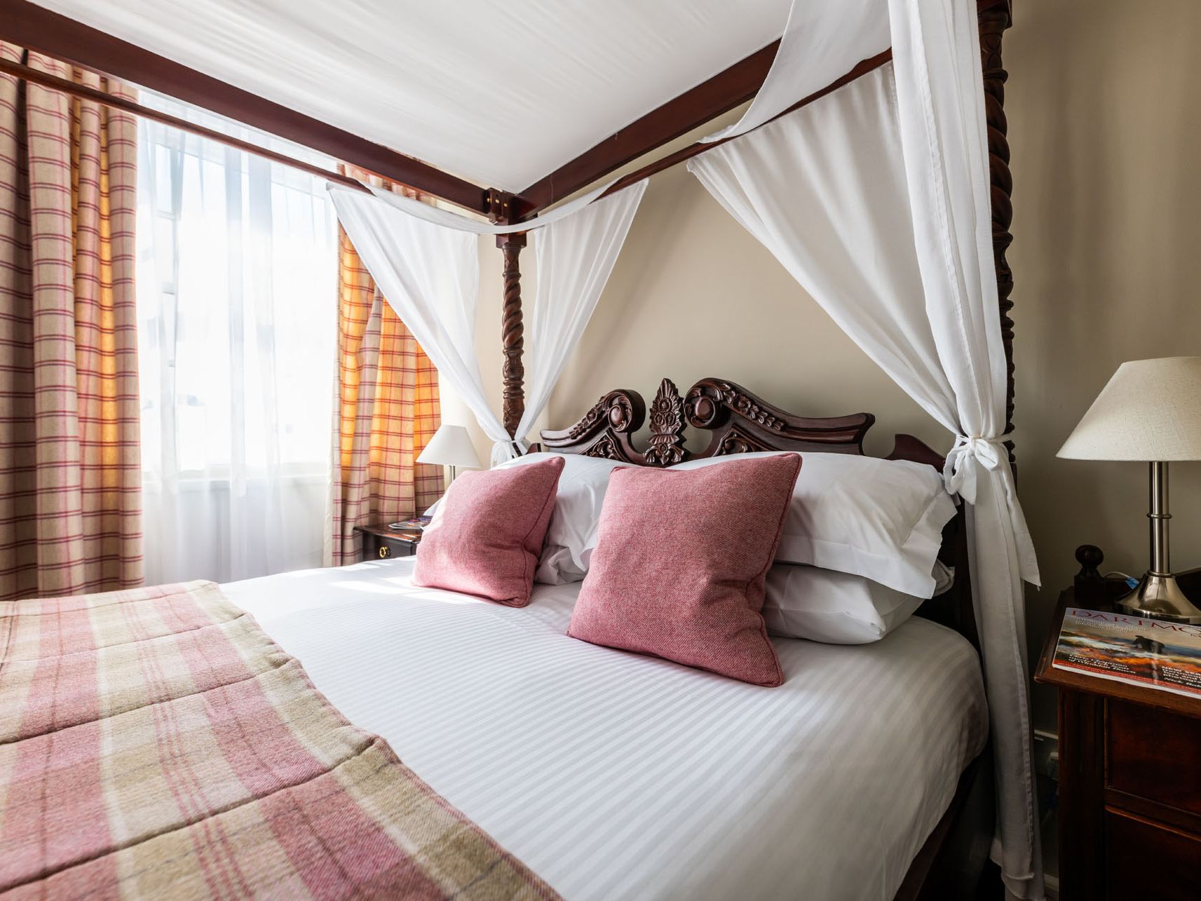 Four poster bed with pink cushions